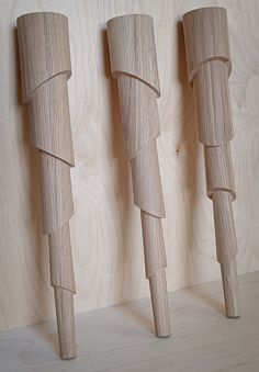 three wooden objects are lined up against a wall