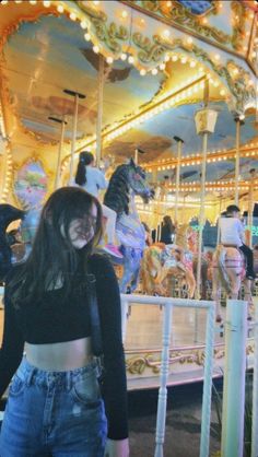 a woman standing in front of a carousel