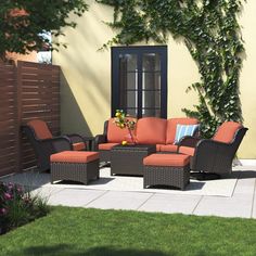 an outdoor patio furniture set with orange cushions