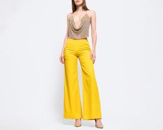 Vintage 90s does 70s bright yellow mid rise pants, with a yoked waist, a side zipper and hook for closure, and a wide flared leg. Measurements and Condition:    Fits like: Labeled size 36, fits US women's extra small Fabric: Feels like cotton/poly Brand: Lightning (on zipper) Condition: Very good, with light general wear, and a couple minor very faint scattered lines where the fabric seems slightly darker (appears to just be imperfections in the fabric).    Waist: 26.5" Hips: 35" - taken at the Yellow High-waist Pants For Party, Yellow Wide Leg Party Pants, Yellow Wide-leg Party Pants, Yellow Wide Leg Pants For Party, Yellow Full Length Bottoms For Fall, Spring Yellow High Waist Wide Leg Pants, Chic Yellow Full-length Bottoms, High Waist Yellow Bottoms For Party, Yellow High Waist Bottoms For Party