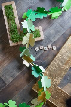 green and gold paper shamrock garland on wooden floor