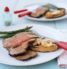 two plates with meat and asparagus on them