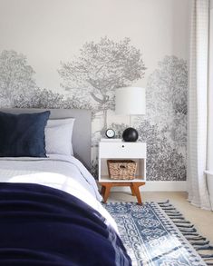 a bed room with a neatly made bed and a night stand next to a window