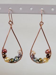 Beautiful teardrop earrings created with the rainbow in mind. Perfect for LGBTQIA+ events or for just enjoying the many different colors of pearls. This design comes with two different metals for the frame and ear wires. Aluminum is both sturdy and light making these comfortable to wear. Copper is still fairly light though slightly heavier than Aluminum but has a more interesting luster and will show age over time.  The stones are real freshwater pearls. I handmake all of these with natural materials so there may be some variation in size, shape, and color. Elegant Multicolor Teardrop Hoop Earrings, Teardrop Pearl Earrings With Metal Ear Wire, Wire Wrapped Pearl Teardrop Earrings, Multicolor Pearl Drop Earrings, Pearl Teardrop Earrings, Rainbow Pearl, Teardrop Earrings, The Rainbow, Ear Wires