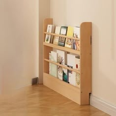 there is a book shelf with many books on it in the corner by the wall