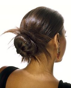 a woman with her back turned to the camera, wearing a black dress and earrings