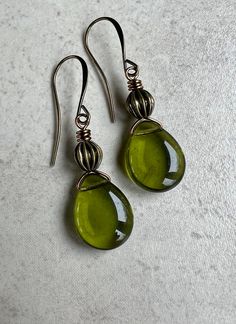 "olive green earrings   boho dangle earrings    czech glass teardrop earrings * Czech glass flat teardrop beads - 12x16mm * transparent shiny olive green color * corrugated antiqued brass bead sits on top * you choose - leverback or hook ear wires - both antiqued     brass * total length - with leverbacks, 1 5/8\" - with hook ear wires,     1 3/4\" * you can enter my shop here:    gypsydangles.etsy.com" Cute 70s Earrings, Green Teardrop Metal Earrings, Glass Teardrop Jewelry With Matching Earrings, Bohemian Green Teardrop Earrings With Ear Wire, Green Metal Dangle Teardrop Earrings, Green Metal Teardrop Earrings, Green Teardrop Drop Earrings Nickel Free, Green Nickel-free Teardrop Drop Earrings, Green Nickel-free Teardrop Earrings