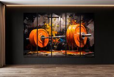 an orange barbell on a black wall in a room with wooden floors and large windows