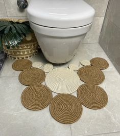 a white toilet sitting in a bathroom next to a rug with circles on the floor