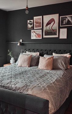 a large bed sitting in a bedroom next to two pictures on the wall above it