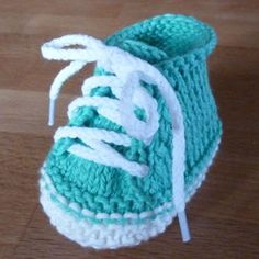 a pair of crocheted shoes sitting on top of a wooden floor with text overlay