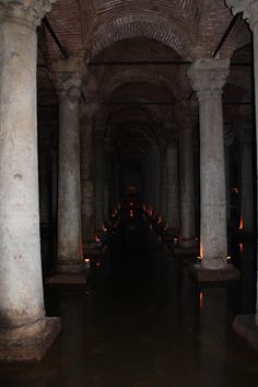 the inside of an old building with columns and candles