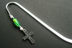 a green and white beaded crucifix with a cross on it's end