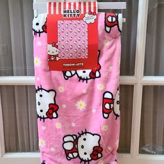 a hello kitty blanket hanging on a window sill