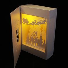 an illuminated box with a house and sleigh on it