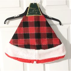 a red and black plaid christmas hat hanging on a door