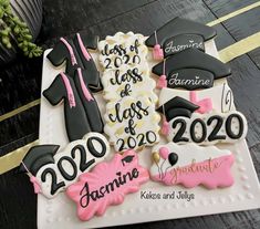 graduation cookies decorated with black and pink icing