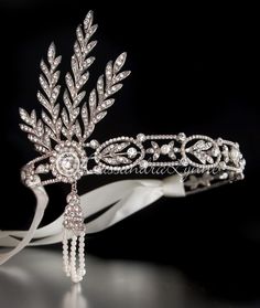 a bridal tiara with crystal beads and leaves on the headband, sitting on a black background