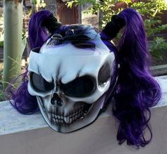 a skull mask with long purple hair and horns