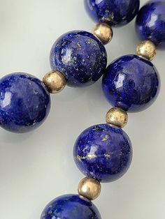 "Cheer up with this genuine blue lapis with gold tone spacer beads. Lapis stones have gold lines and are approx. 8mm. round Clasp: filigree fishhook Length approx. 25\" Condition: Good vintage" Elegant Round Lapis Lazuli Beaded Necklaces, Elegant Round Beaded Lapis Lazuli Necklace, Elegant Round Lapis Lazuli Beaded Necklace, Formal Lapis Lazuli Jewelry With Round Beads, Classic Round Lapis Lazuli Jewelry, Classic Blue Round Beads Jewelry, Classic Blue Round Bead Jewelry, Single Strand Lapis Lazuli Round Bead Jewelry, Lapis Lazuli Round Beaded Necklaces