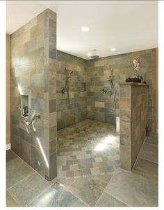 a bathroom with tiled walls and flooring in the shower area is shown here, there are two faucets on either side of the walk - in shower