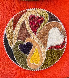 a close up of a quilted table top with many different colored beads on it