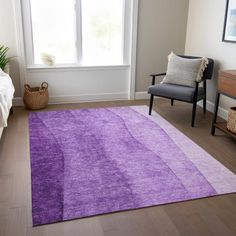 a living room with a purple rug on the floor next to a chair and window