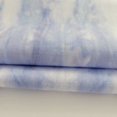 two pieces of blue fabric sitting on top of each other in front of a white background