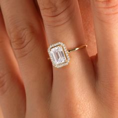 a woman's hand with an engagement ring on it and a diamond in the middle