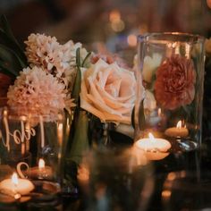 flowers and candles are sitting on the table