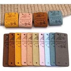 six different colored leather tags with the words, bees and flowers on them are lined up in