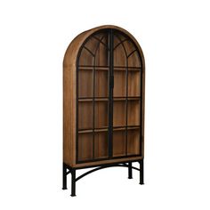 an arched wooden bookcase with glass doors