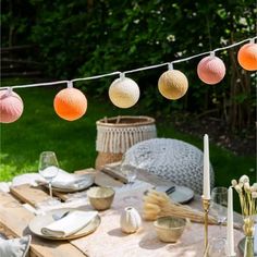 an outdoor table set with plates and candles