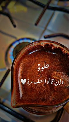 a jar filled with lots of liquid on top of a metal table covered in writing