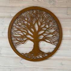 a metal tree with no leaves is mounted on a wooden wall above a wood paneled floor