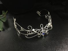 I wanted to create a magical and beautiful bohemian renaissance crown, also called a circlet, in all sterling silver, to which I've designed substantially to last a lifetime of enjoyment. Inspired by Lord of the Rings/Middle Earth with an Elvish Celtic feel, this headpiece can be worn not only for a bridal theme, but at any Renaissance event as well. This piece fits back towards the ears and has elastic fasteners to position in place for a secure and snug fit for your head shape. You will need t Bohemian Round Crown Headpiece For Wedding, Bohemian Wedding Headpiece With Round Crown, Wedding Jewelry With High Crown And Crown Design, Handmade Elegant Festival Headpiece, Elegant Handmade Festival Headpiece, Bohemian Wedding Jewelry With Artistic Design, Handmade Teardrop Crown Headpiece For Weddings, Elegant Silver Headpiece With Teardrop Crown, Handmade Pinched Crown As A Gift