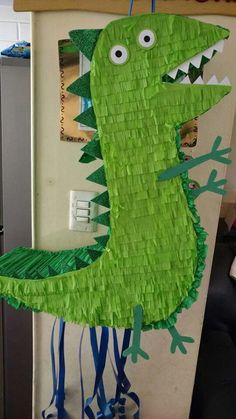 a paper plate alligator is hanging on the wall