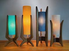 three lamps with different shades on them sitting next to each other