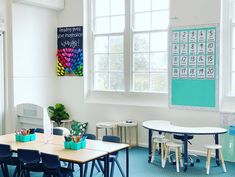 an empty classroom with desks and chairs in front of two large windows that have calendars on them