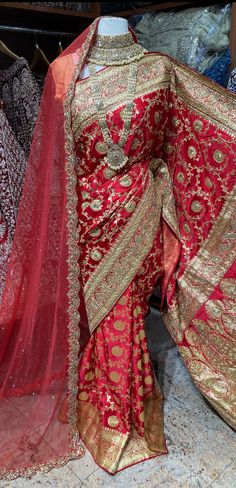 Bright red pink banarasi saree brilliantly crafted motifs in woven, stone and zardosi with zari weaved border and pallu around the drape captivates one towards it. The saree has an unstitched blouse and a net dupatta perfect edit to your wedding rituals. Beautifully teamed with traditional pearl bridal jewelry set is perfect for wedding. Fabric: Pure Silk Occasion: Wedding Ceremony or Reception. WASH CARE INSTRUCTIONS - Please Dry clean only when it is applicable. Slight color variation is possi Luxury Red Zari Work Dupatta, Luxury Zari Work Dupatta For Marriage, Luxury Red Dupatta In Traditional Drape, Luxury Saree With Dabka Work For Traditional Ceremonies, Luxury Saree With Dabka Work For Wedding, Luxury Red Handwork Saree, Luxury Red Traditional Wear With Zari Weaving, Luxury Red Dupatta For Ceremonial Occasions, Luxury Red Dupatta For Festivals