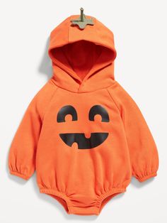 an orange baby bodysuit with a black face on the chest and eyes painted on it