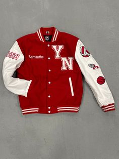 a red and white jacket with the letter yn on it, sitting against a gray wall