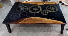 a coffee table made out of wood and gears on the top, with metal legs