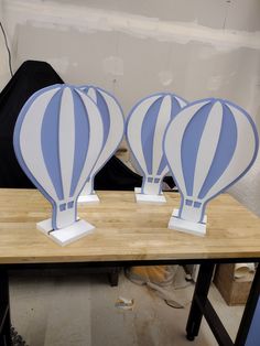 three blue and white hot air balloons on a table