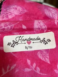 a label on a pink bag that says handmade by you with leaves and hearts