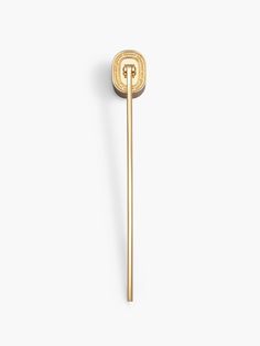 a gold tie pin with the letter t on it's end and a circle in the middle