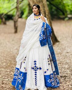 This Habesha Kemis is a true work of art, with its stunning Menen fabric and intricate blue design. The Menen fabric is known for its softness and durability, making this Kemis not only beautiful but also comfortable to wear. The blue design is both striking and delicate, with a pattern that is reminiscent of the intricate designs found in traditional Ethiopian art and textiles. The blue design extends down the front of the Kemis, creating a visually stunning centerpiece that draws the eye and c Blue Bohemian Unstitched Dress, Blue Chikankari Embroidered Dress With Traditional Drape, Blue Kurta With Traditional Patterns For Ceremonies, Transitional Blue Kurta For Traditional Ceremonies, Blue Bohemian Traditional Wear For Wedding, Bohemian Blue Traditional Wear For Wedding, Blue Dresses With Pallu For Transitional Season, Blue Cotton Wedding Dress, Bohemian Blue Traditional Wear For Navratri