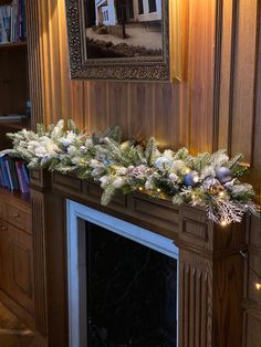 a mantel decorated with christmas garland and lights