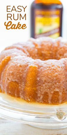 a bundt cake sitting on top of a glass plate next to a bottle of syrup