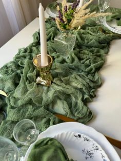 a white table topped with plates and candles